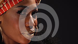 Close up face traditional headdress beautiful Afro American young woman looking at camera isolated on black background