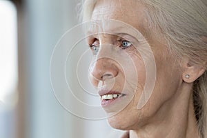 Close up face view pensive senior woman looking into distance photo