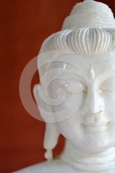 Close-up face of a white stone Buddha image