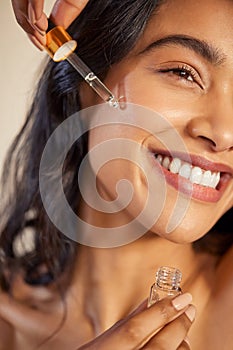 Close up face of woman applying anti aging serum on face