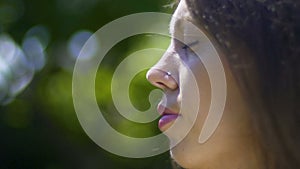 Close-up face of woman with closed-eyes, meditation in park, outdoor relaxation