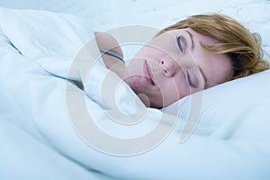 Close up face of young attractive woman with red hair sleeping peacefully lying in bed at home