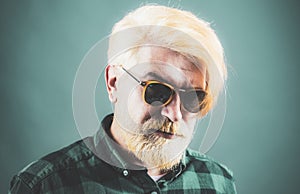 Close-up face of young bearded man on dark background - professional studio light.