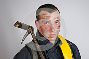 Close-up face of young brave man in uniform of firefighter and crowbar tool
