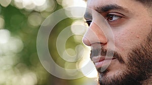 Close up face young caucasian bearded man portrait looking away serious confident beautiful young urban casual