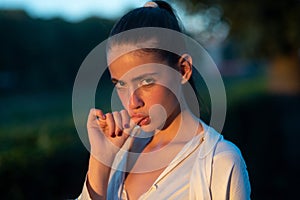 Close up face of young woman. Girl sucking thumb on. Beautiful young woman, girl with smoke marijuana sign. Suck finger