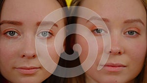 Close-up faces of identical twin sisters looking at camera. Slim beautiful young Caucasian women posing. Sisterhood and