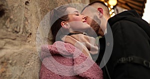 Close-up of the faces of a young couple in love kissing and hugging on the street