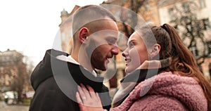 Close-up of the faces of a young couple in love kissing and hugging on the street