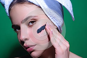 Close up facial cream on cheek. Beauty portrait of a beautiful woman applying face cream. Woman applying moisturizing