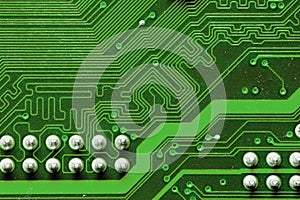 Close-up of a factory printed circuit board of electronics with pin tracks. Electronic background green tint