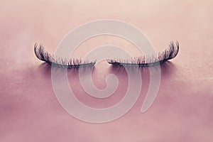 Close up false eyelashes on pink background