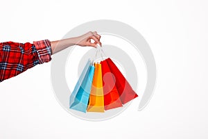 Close up of famale hand holding small colorful shopping bags over isolated white background