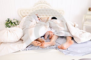 Close-up family feet that lie and sleep on bed