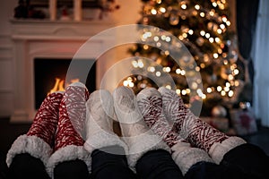 Close up of family feet warming up by the fireplace