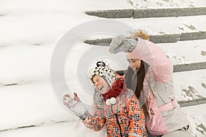 Close up of family sit on snowy steps and have a fun