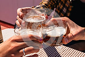 close-up of a family toast with a glass of beer on a sunny day on a terrace