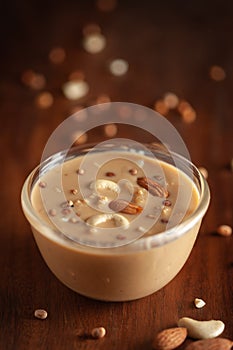 Close up of a famous Bengali dessert `Nolen Gurer Chanar Payesh` or Milk pudding of cottage cheese in a glass bowl. Top-down view