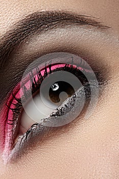 Close-up of fashion eyes make-up, bright magenta eyeshadow, dark eyebrows