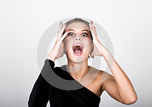 Close-up fashion photo young lady in elegant black dress, playful woman caught himself with his hands behind his head