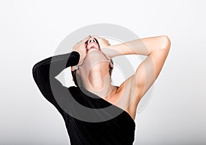 Close-up fashion photo young lady in elegant black dress, playful woman caught himself with his hands behind his head