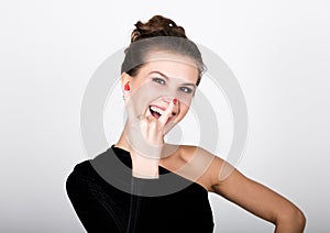 Close-up fashion photo young lady in elegant black dress, playful woman smiling and shows a sign of heavy metal