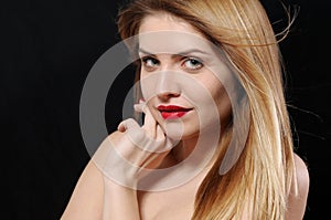 close up fashion portrait of beautiful young blonde woman on black background