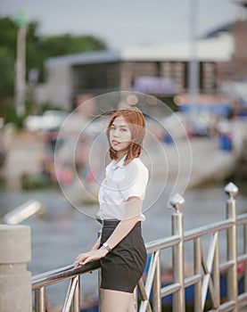 Close-up Fashion woman portrait of young pretty trendy girl posing at the bridge in Thailand,in university uniform