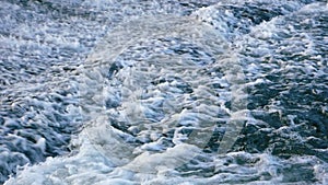 Close up of fast flow of river water. Foamy water. Cold fast mountain river. Water river flows. Selective focus, shallow depth of