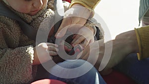 Close-up of fastening the lock in the car seat. Father puts the child in the car