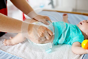 Close-up of father changing diaper of his newborn baby daughter.