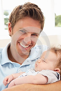 Close Up Of Father Cuddling Newborn Baby Boy At Ho