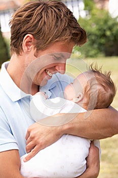 Close Up Of Father Cuddling Newborn Baby Boy Outdo