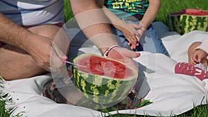 Close Up of Father Cutting Watermelon Outdoors