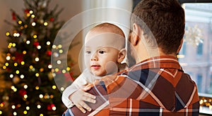 Close up of father holding baby son on christmas