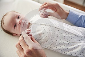 Close Up Of Father Holding Newborn Baby Sons Hands In Nursery