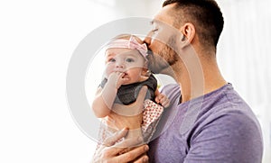 Close up of father kissing little baby daughter