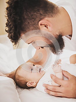 Close up. Father Playing with Baby in Bed at Home.