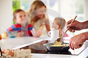 Close Up Of Father Preparing Family Breakfast In Kitchen