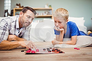 Close-up of father and son playing checker game