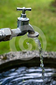 Close-up of a faucet with running water outside