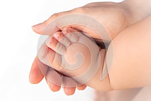 Close-up feet of baby in the hand of mother.