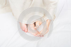 Close-up of the feet of a couple on the bed