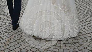 close-up of the feet of the groom and the bride going forward. back view .