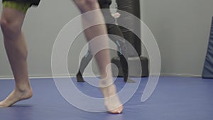 Close up of feet of the man and woman having training in the gym. Warming up before sparring. Male and female legs