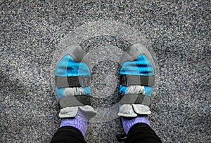 Close up of feet wearing indoor climbing wall shoes standing on soft flooring safety mat.