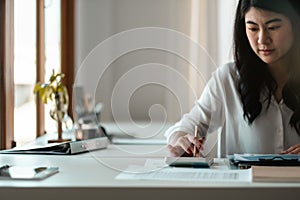 Close up of female accountant or banker making calculations. Savings, asian woman working for finances and economy