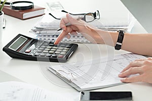 Close up of female accountant or banker making calculations photo