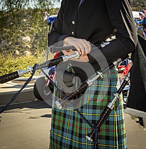 Close up of female bag piper holding bagpipes