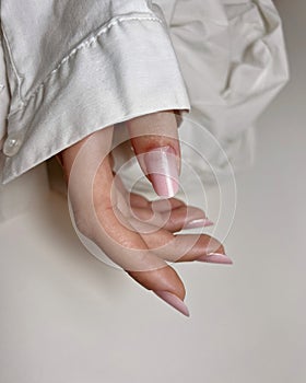 Close-up of a female with carefully manicured pastel pink fingernails